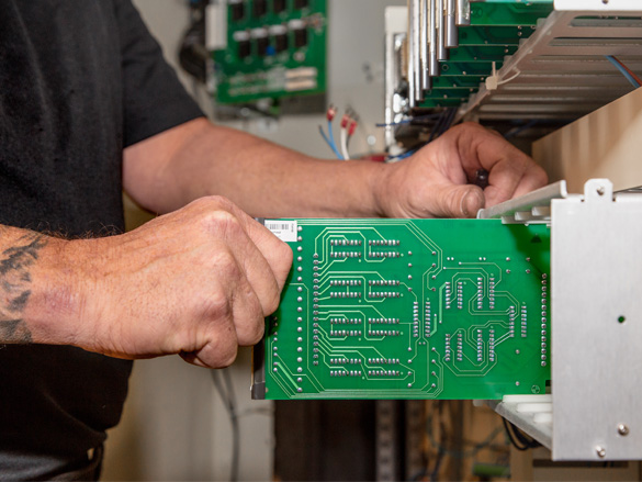 a man's hands displaying a printed circuit board